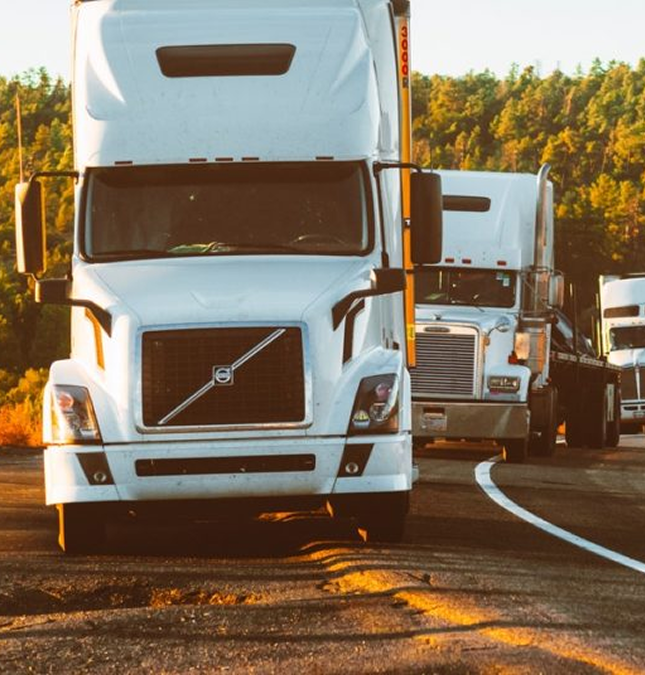 Trucks queued on a highway at sunset